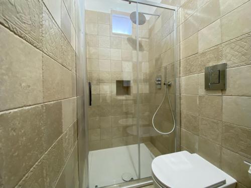 y baño con ducha, aseo y lavamanos. en Uria Rooms & Suite B&B, en Vieste