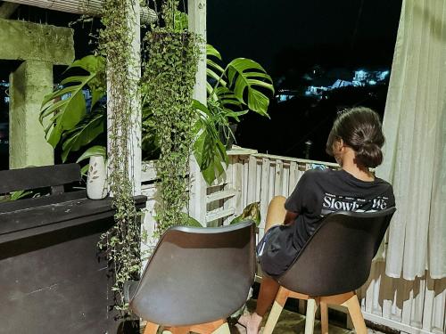 a woman sitting in a chair on a balcony at De Nata in Labuan Bajo