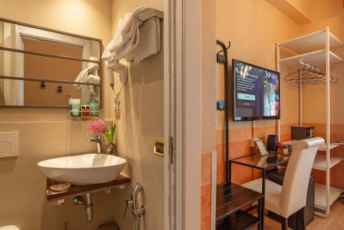 a bathroom with a sink and a television in it at Hotel Jane in Florence