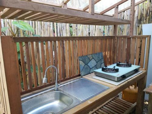 a outdoor kitchen with a sink and a stove at Cabin D at Bigang Munti in Batangas City