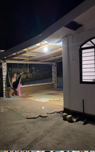 Una mujer en una hamaca en un garaje por la noche en Emmasguesthouse, en Paracale