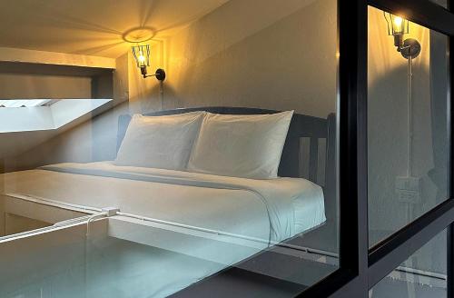 łóżko z białą pościelą i poduszkami w pokoju w obiekcie Stay Thought w mieście Surat Thani