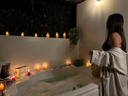 a woman standing in a bath tub with candles at MISKI SAMAY DOMO BOUTIQUE in Urubamba