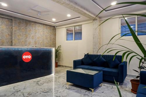 a living room with a blue couch and a tv at Super OYO Esta Inn in Pune