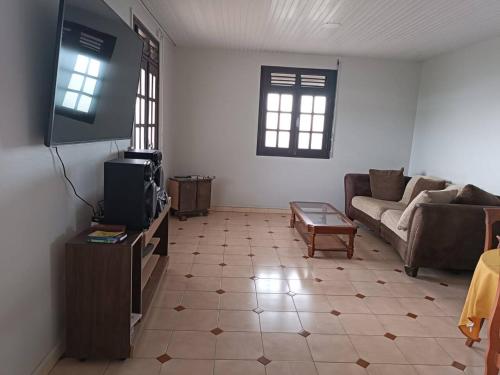 a living room with a couch and a tv at Maison de 4 chambres avec jacuzzi terrasse et wifi a Riviere Pilote a 3 km de la plage in Rivière-Pilote