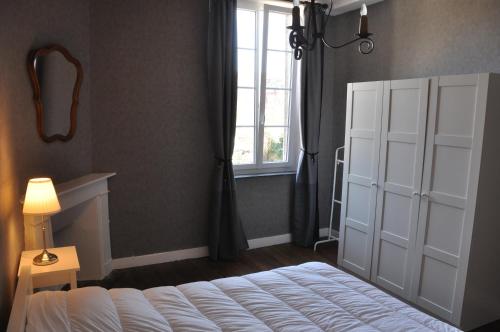 a bedroom with a white bed and a window at La Fumacienne in Fumay