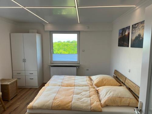 a bedroom with a large bed and a window at SUNRISE mit großer Terrasse und Weitblick in Pirmasens