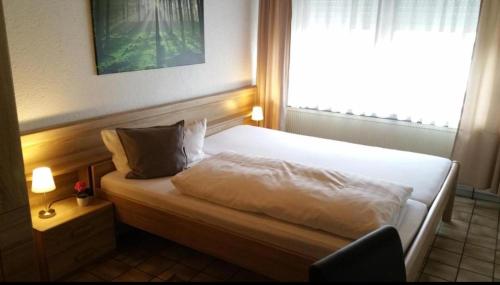 Schlafzimmer mit einem weißen Bett und einem Fenster in der Unterkunft Seelbacher Hof in Herborn