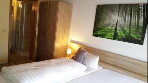 1 dormitorio con 1 cama y una pintura en la pared en Seelbacher Hof en Herborn