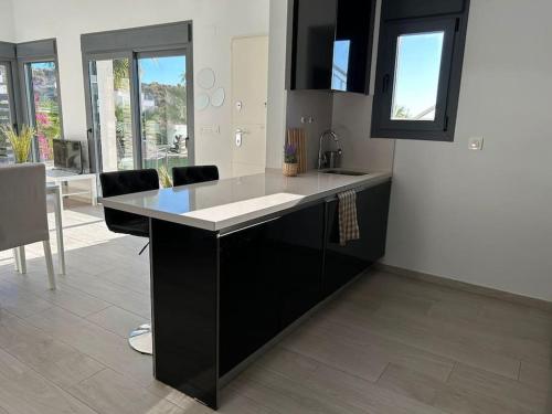 a kitchen with a black and white counter top at Villa Tropical - Alegría Village in Finestrat