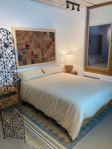 a bedroom with a bed with a picture on the wall at Loft estilo industrial en Esplugues - 15 min de Barcelona in Esplugues de Llobregat