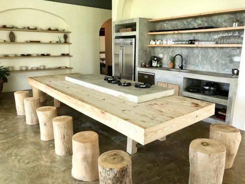 uma cozinha com uma mesa de madeira e alguns troncos em OYA - Wellness Eco Resort & Retreat em Jamao al Norte