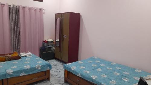 ein Schlafzimmer mit 2 Betten und einer Kommode darin in der Unterkunft RG Homestay in Nāmdāng