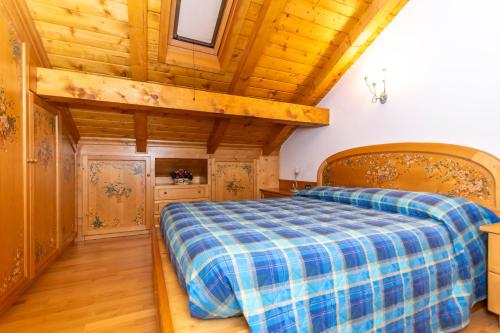 a bedroom with a bed and a wooden ceiling at mansarda Lungolago in Alleghe