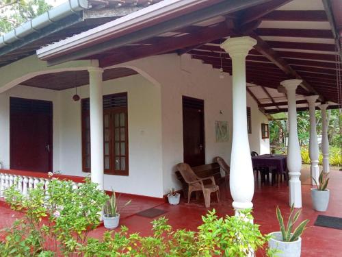 un porche de una casa con columnas y plantas en Villa Samudra Hikkaduwa en Hikkaduwa