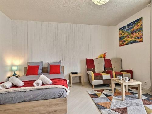 een slaapkamer met een bed met rode kussens en een bank bij L'Escapade Perchée*Disney*Paris* in Pomponne