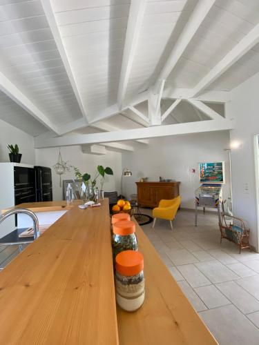 una cocina con una larga mesa de madera con naranjas. en Les tranquilles d'Oléron en La Cotinière