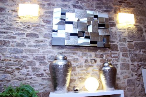 two vases sitting on a table with lights on a wall at Hotel Montenegro Compostela in Santiago de Compostela