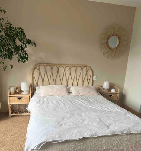 une chambre avec un lit blanc avec deux tables de nuit dans l'établissement Villa avec piscine en Baie Mont St Michel dans un parc arboré, à Le Val-Saint-Père