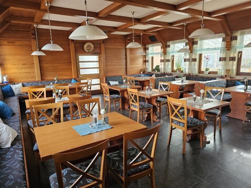 Un comedor con mesas y sillas de madera. en Hotel Tennenloher Hof, en Erlangen