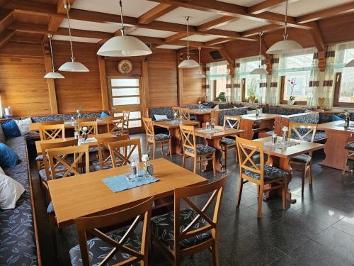 Hotel Tennenloher Hof في إيرلنجين: غرفة طعام مع طاولات وكراسي خشبية