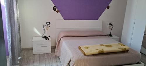- une chambre avec un lit au plafond violet et blanc dans l'établissement L'antica torre, à Tuscania