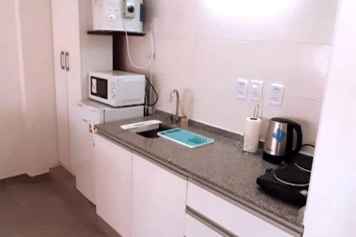 a small kitchen with a sink and a microwave at Departamento en Mendoza in Mendoza