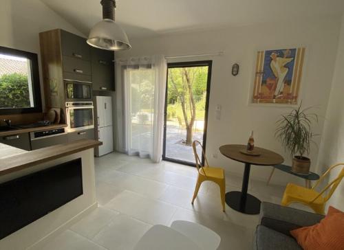 cocina y sala de estar con mesa y TV en Gîte Corsi Gallega, en Sauzet