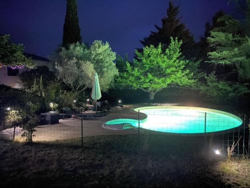 una piscina en un patio por la noche en Gîte Corsi Gallega, en Sauzet