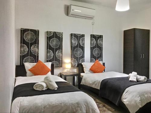 a room with two beds with orange and white pillows at Pensiunea La Bozi in Utvin