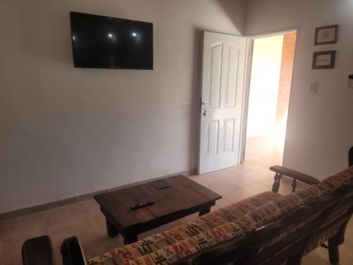 sala de estar con sofá y TV en la pared en Hermosa Casita paso patria III en Paso de la Patria