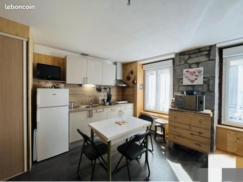 une cuisine avec une table et quelques chaises dans l'établissement Studio au cœur du centre ville, à Le Mont-Dore