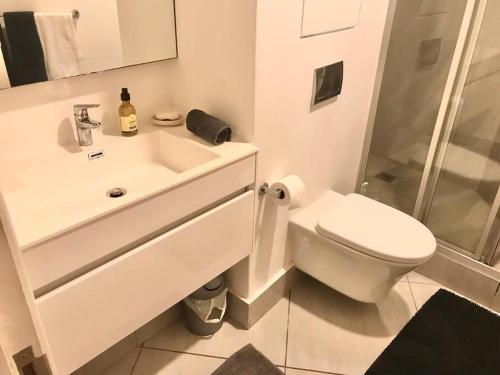 a white bathroom with a toilet and a sink at 1 bedroom apartment in Sibaya in Sibaya