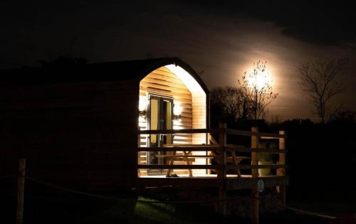 a small house at night with a light in the window at The Getaway - The Buzzard - Luxury Family Glamping Cabin in Dungarvan