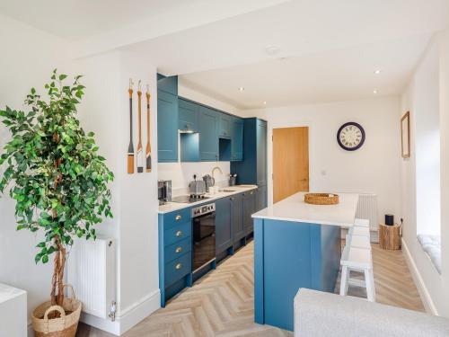 a kitchen with blue cabinets and a white counter top at Townhouse in Llandudno