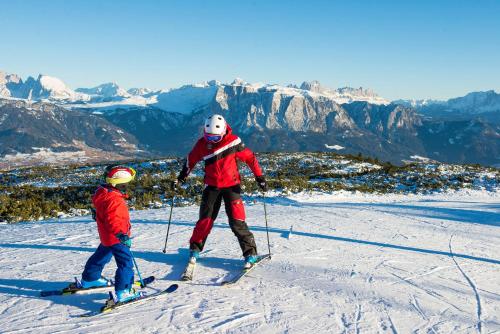 a woman and a child on skis in the snow at Ferienwohnung Biene - Moosbachhof in Collalbo