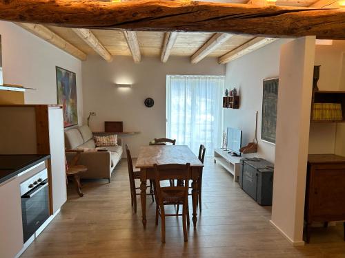 una cucina e un soggiorno con tavolo e sedie di Casa Renzo ad Arco