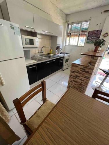 uma cozinha com uma mesa de madeira e um frigorífico em Luminoso apartamento a minutos de Playa Mansa em Maldonado