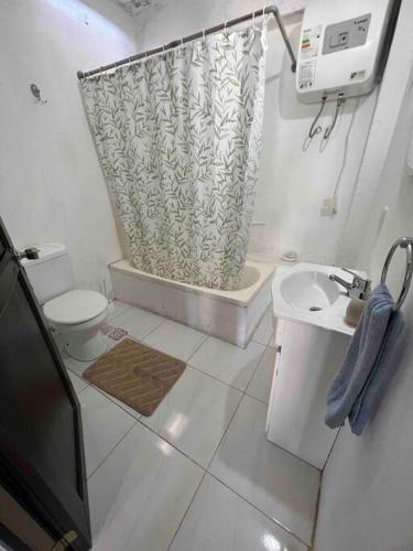 uma casa de banho com uma cortina de chuveiro e um WC em Luminoso apartamento a minutos de Playa Mansa em Maldonado