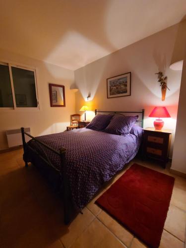 - une chambre avec un lit doté de draps violets et d'un tapis rouge dans l'établissement Villa Aurea, à Hyères