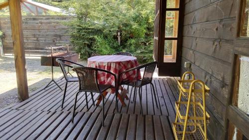 una mesa y sillas sentadas en una terraza en Cabañas sueños del sur, en Caburgua