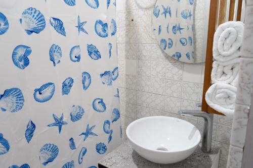 a bathroom with a toilet and a blue and white shower curtain at HOTEL GANADERO in La Dorada