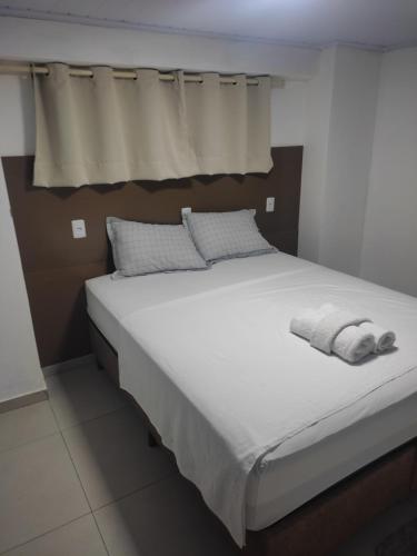- un lit avec 2 serviettes dans une chambre dans l'établissement Apartamento Central, à Ametista do Sul