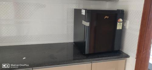 a black refrigerator sitting on a counter in a kitchen at Room2go in Bangalore