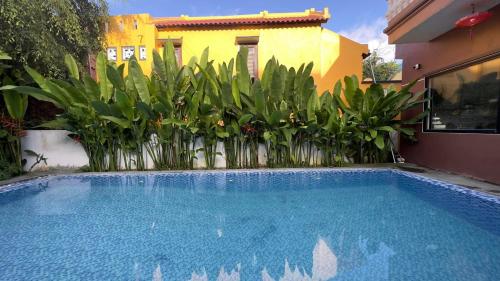 a swimming pool in front of a house with plants at An Bang Gold Coast Beach Villa in Hoi An