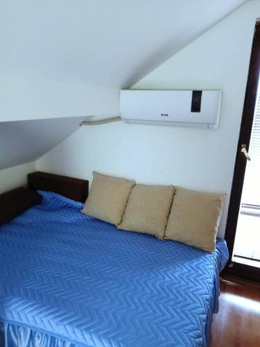 a bedroom with a bed with a blue comforter at DRAGICA Manastirska 10 in Ljubovija