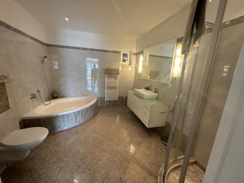 een badkamer met een bad, een toilet en een wastafel bij Mühlberg Apart in Reith bei Seefeld