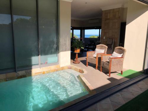 a hot tub in a patio with wicker chairs at Marine 5 Boutique Hotel in Gansbaai