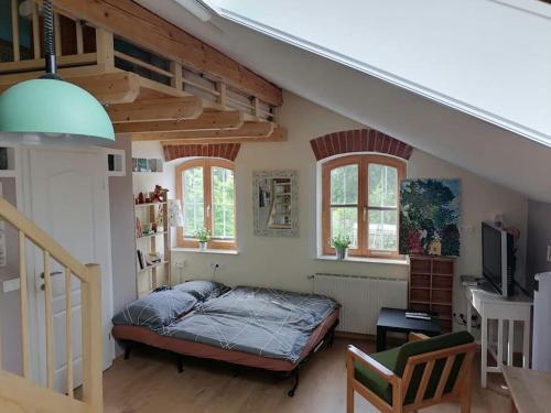 a bedroom with a bed and a staircase with windows at Atelieo beim Nussbaum in Ternitz