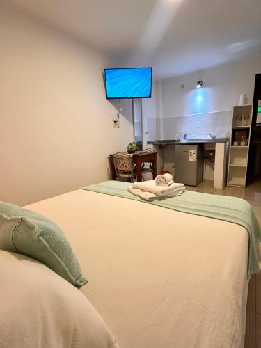 um quarto com duas camas e um ecrã azul na parede em Tiny Room Ingá em Colón